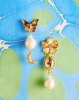 Stylized shot of the joy tea party earrings on marbled blue and green paper background