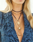 Model wearing mix of moon and star pendants on gold chains and lapis beaded double wrap