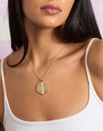 Model wearing the split by love engravable pendant on the classic rolo chain with sample engraving of R and B