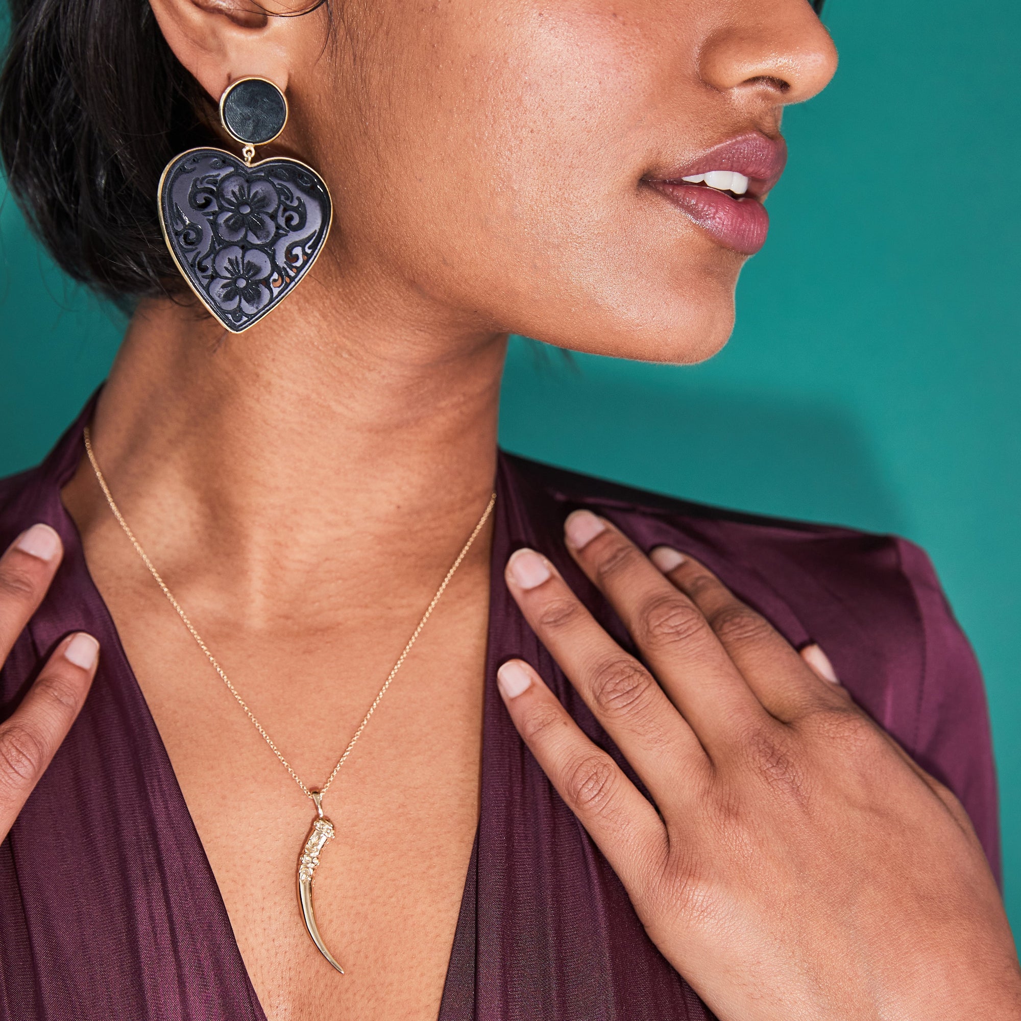Model wearing carved black agate heart earrings