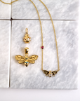 Stylized shot of bee pendant, bee necklace, and ladybug pendant