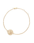 Delicate gold bracelet featuring tiny coin with morning glory design