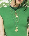 Model wearing layered gold necklaces