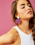 Model wearing fuchsia heart drop earrings