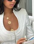 Gold coin pendants layered on model