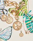 Stylized laydown image of gold Butterfly coin pendants with sketch of design