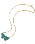 Stone butterfly necklace on gold chain features carved malachite stones for the wings and pink tourmaline accents on the body
