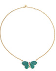 Stone butterfly necklace on gold chain features carved malachite stones for the wings and pink tourmaline accents on the body