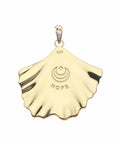 Back of gold ginkgo leaf pendant features moon and star logo and the word HOPE