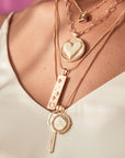 Model wearing layered gold necklaces
