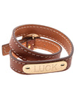 Brown leather wrap bracelet with gold plate that features sample engraving of the word LUCK