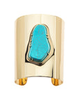 Shiny gold cuff featuring a chunky piece of turquoise