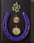 Stylized laydown image of gold Lucky coin pendants with purple horseshoe