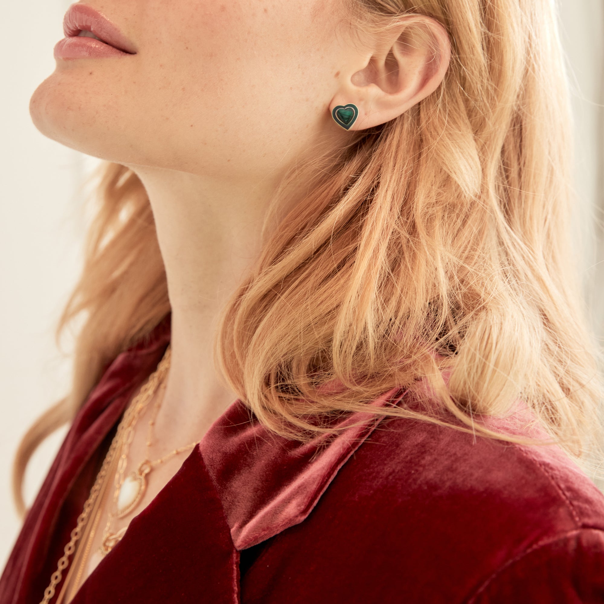 Model wearing malachite heart studs