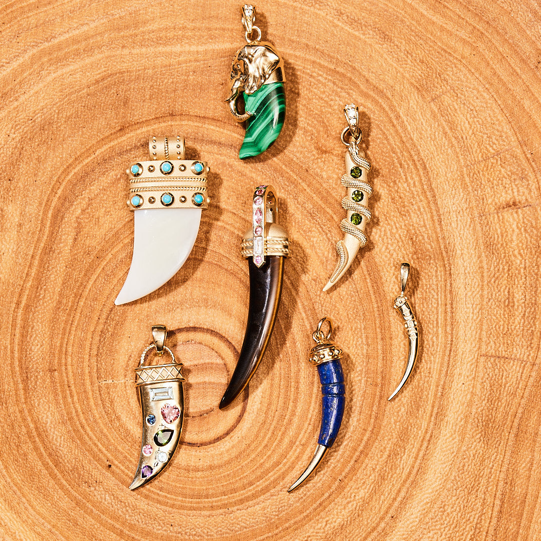 Stylized shot of various tusk pendants on piece of wood
