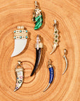 Stylized shot of various tusk pendants on piece of wood