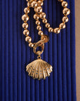 Stylized shot of the strong in the waves shell with the sun reflection beaded chain