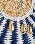 Stylized shot of the strong along the shore earrings and strong along the shore pendant on the blue omega wire. Shown on a blue and white woven basket
