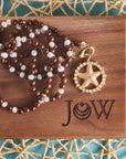 Stylized shot of the strong light of the ocean pendant with the wood and pearl double wrap chain
