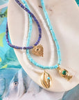 Stylized shot of the strong in the waves necklace, strong keep swimming necklace, and protect eye on your heart necklace
