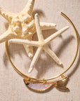 Stylized shot of the keep swimming fish on the gold neck cuff photographed with starfish