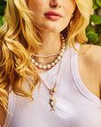 Model wearing various pearl necklaces and the strong amore fish pendant