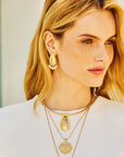 Model wearing the strong along the shore oyster shell earrings