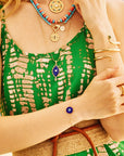 Model wearing the protect traveling eye bracelet, as well as various evil eye pendants