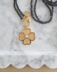Stylized shot of the joy dogwood flower on the black agate double wrap chain