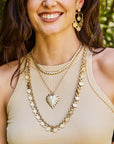 Model wearing the love amore coin necklace, full heart pendant, made from love tennis necklace, and the love amore coin earrings