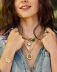 Model wearing the petite curb chain, courage horse petite embellished coin, courage horse cutout coin, and courage year of the horse bracelet