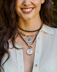 Model wearing the black opal double wrap with the forever carved sundial pendant