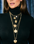 Model wearing assorted gold pendants and chains