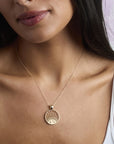 Model wearing the strong rising sun cutout coin pendant on a delicate chain