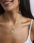 Model wearing lucky cutout coin pendant on a delicate chain