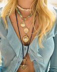 Model wearing various resort collection pendants and beaded chains