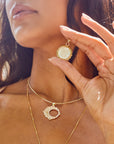 Model holding mother of pearl moon face pendant