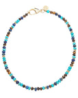 Beaded necklace with turquoise, lapis, and tigers eye beads and flat gold beads interspersed. Features oversized gold lobster clasp.
