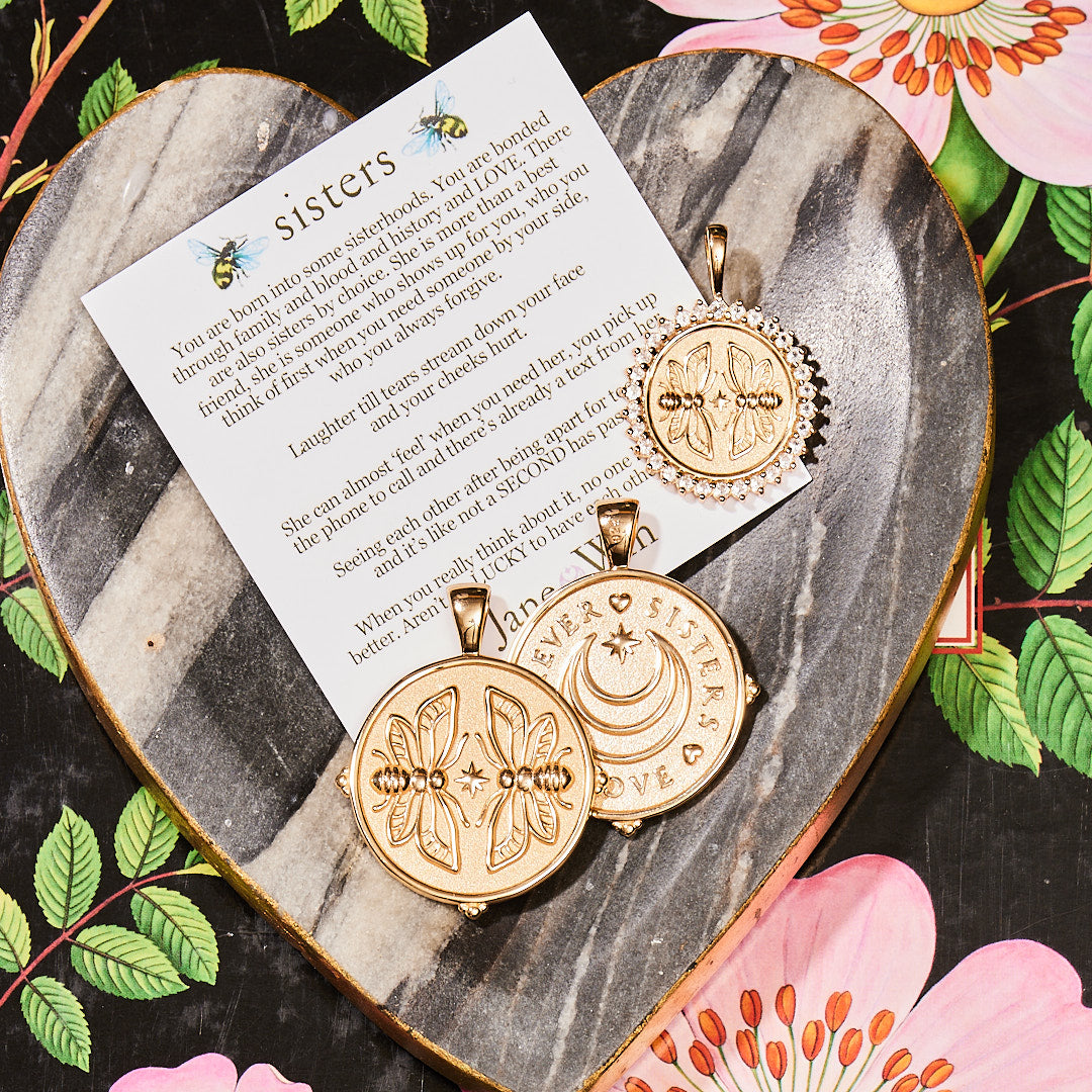Stylized laydown image of three gold coin pendants with card and meaning