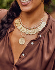 Model wearing each of the small gold zodiac pendants