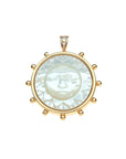 Gold coin pendant features mother of pearl inlay carved with sun face, as well as white topaz accents on the bail