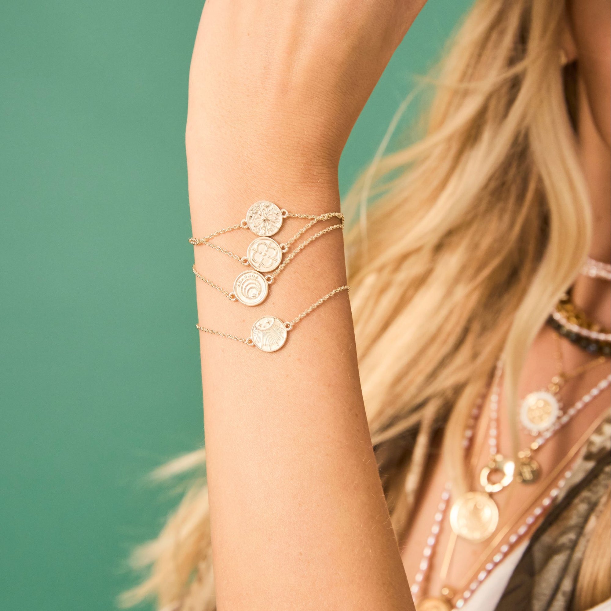 Model wearing each of the baby coin bracelets