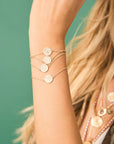 Model wearing each of the baby coin bracelets