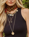 Model wearing lucky charm necklace layered with wishbone pendant and lucky coin