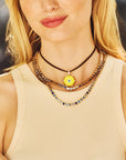 Model wearing the protect traveling eye pendant layered with the made with love tennis necklace in blue