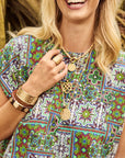 Model wearing layered gold love pendants