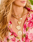 Model wearing layered gold hope pendants