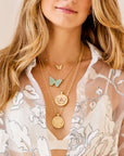 Gold butterfly pendants layered on model