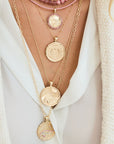 Gold coin necklaces layered on model