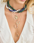 Model wearing layered horseshoe pendants